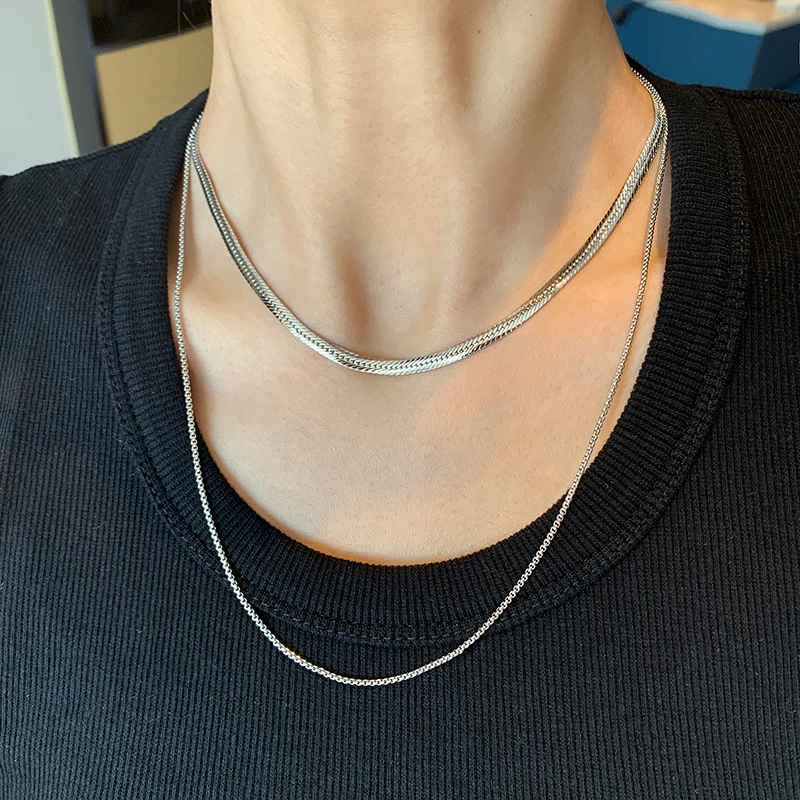 Close-up of a stylish gold necklace, featuring linked chain design, worn by a model.