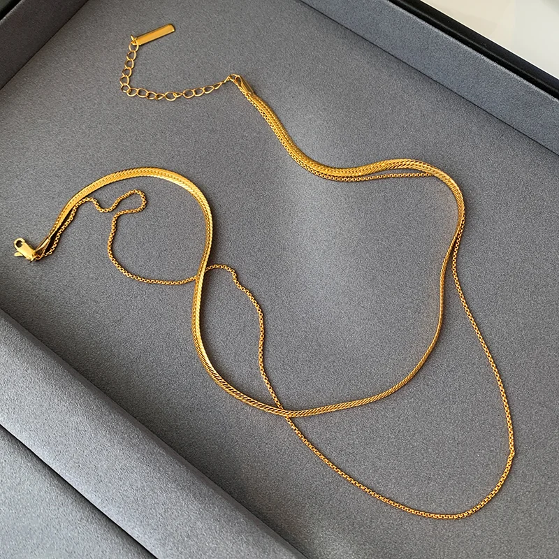 Close-up of a stylish gold necklace, featuring linked chain design, worn by a model.